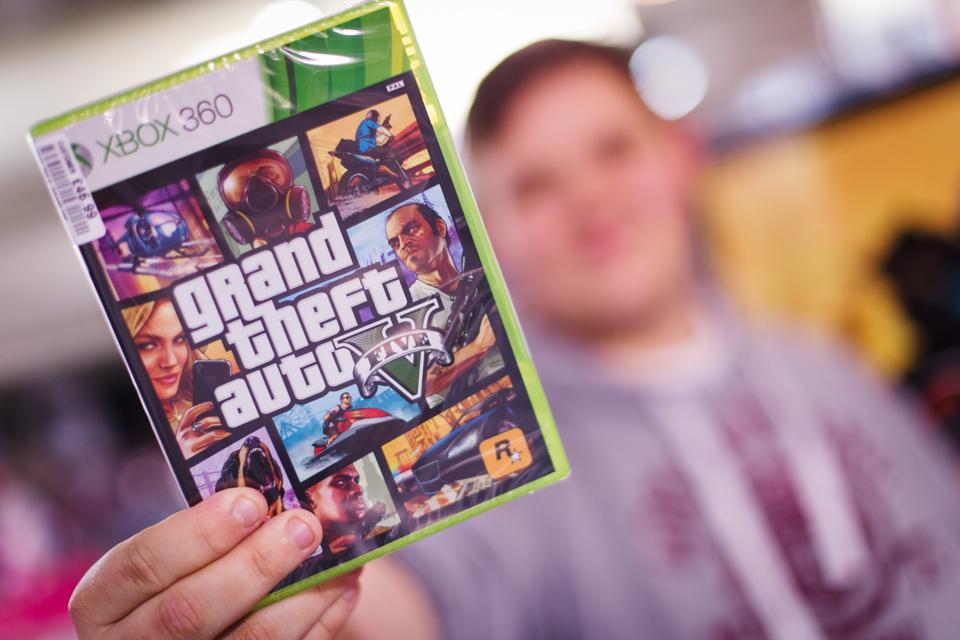 Boy poses with Grand Theft Auto 5 box.