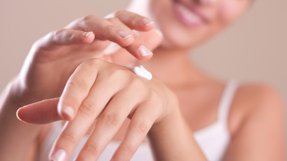 A woman applying hand lotion onto her hands