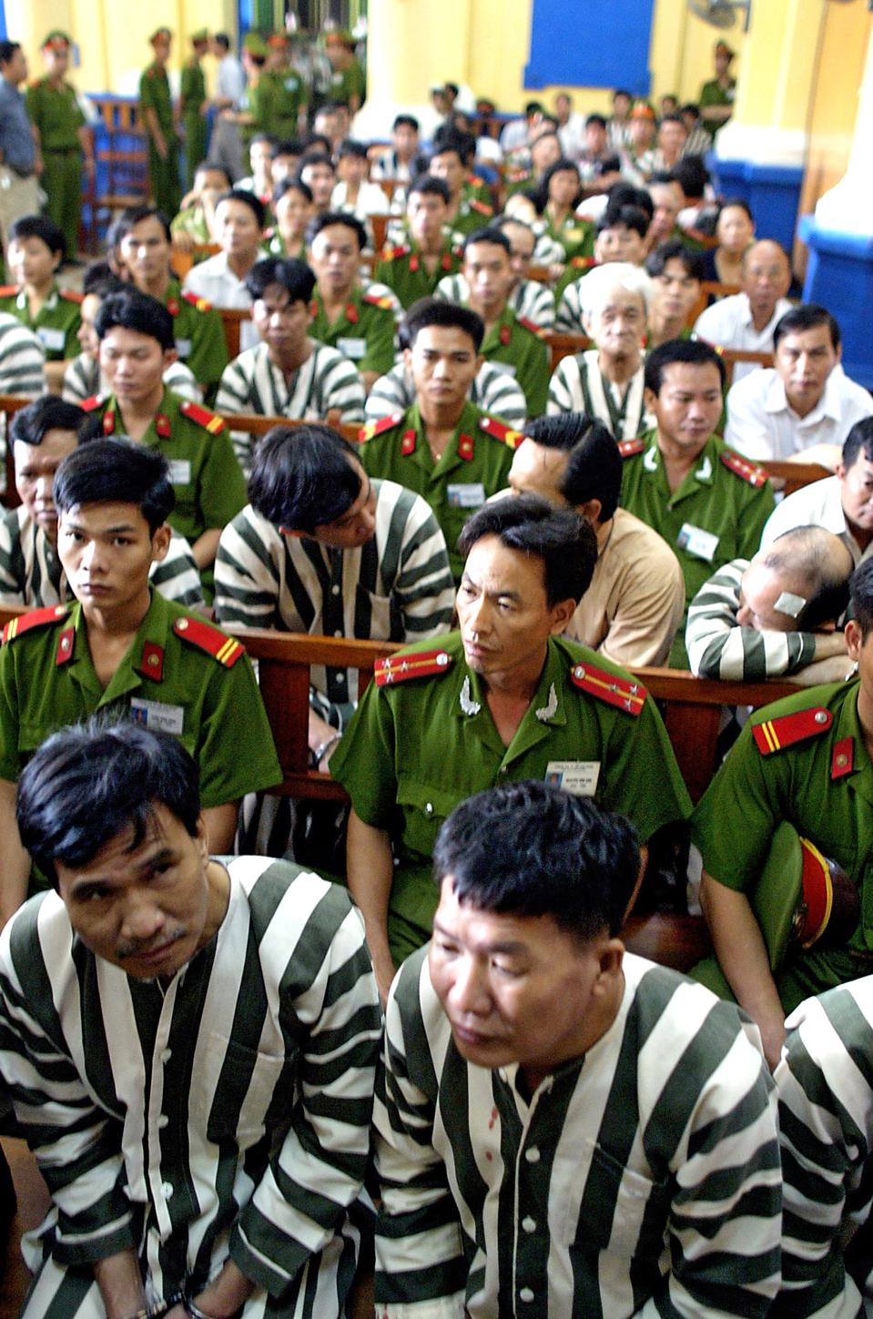 Defendants and police await a verdict during a corruption trial in Ho Chi Minh City's court in June 2003. (AP Photo/Richard Vogel, FILE)