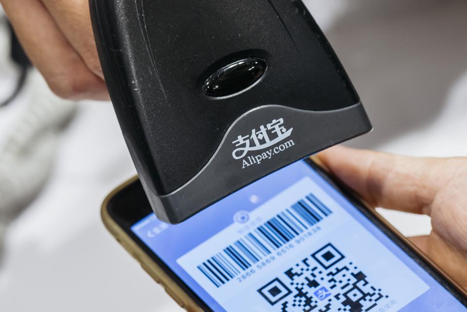 An employee scans a quick response (QR) code displayed on the Ant Financial Services Group's Alipay app.(Photo by Anthony Kwan/Bloomberg)