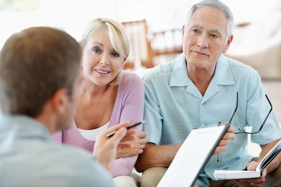 A mature couple discussing their finances with their advisor