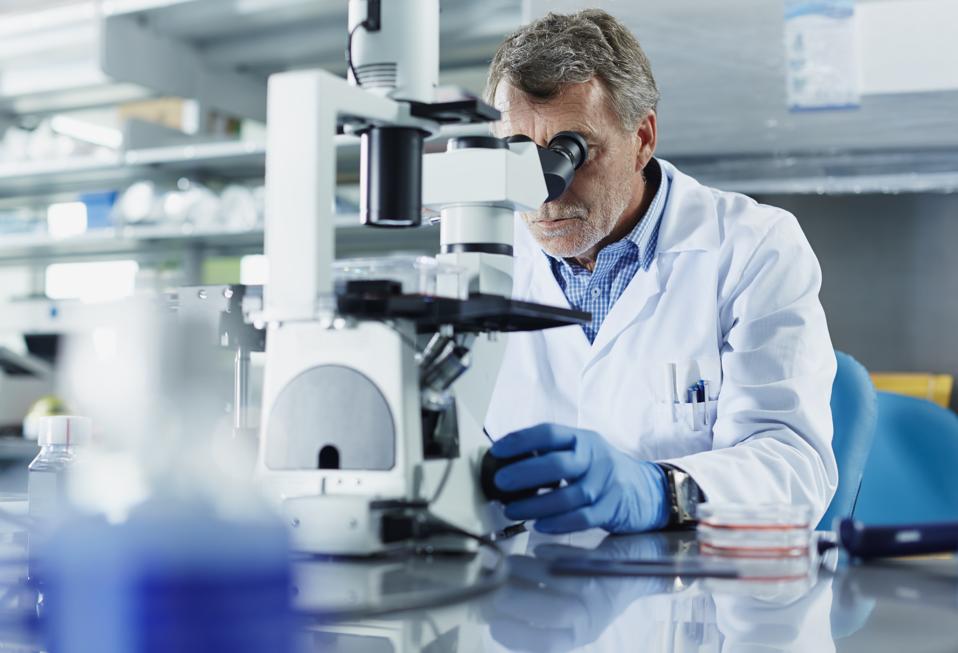 Scientist looking through microscope