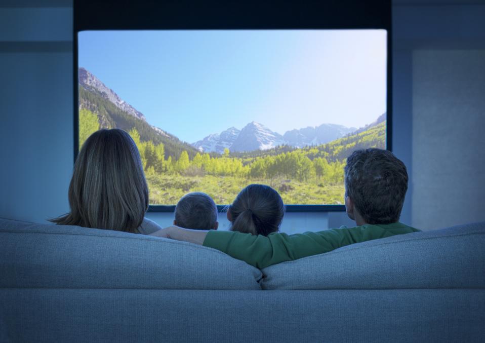Family watching television in living room