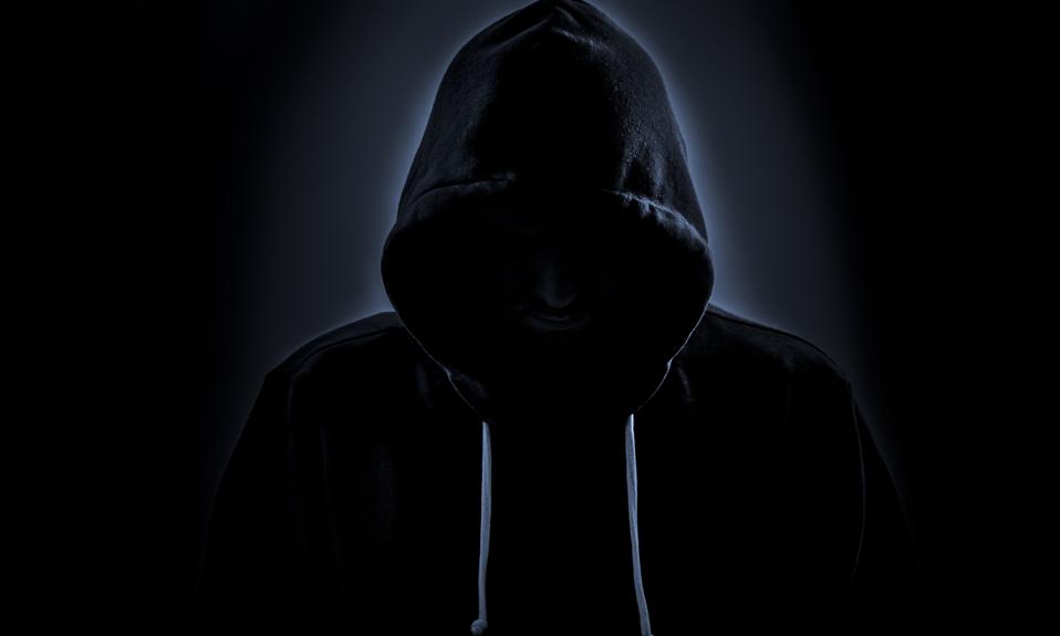 Hooded hacker in dark