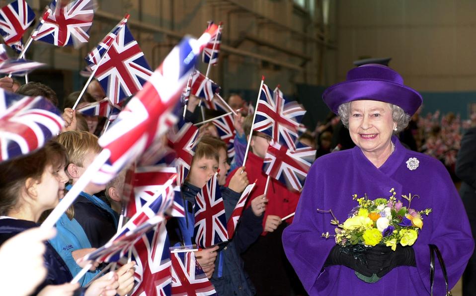 Queen Elizabeth surrounded by children with flags