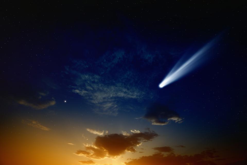 An illustration of a bright comet close to a sunset.