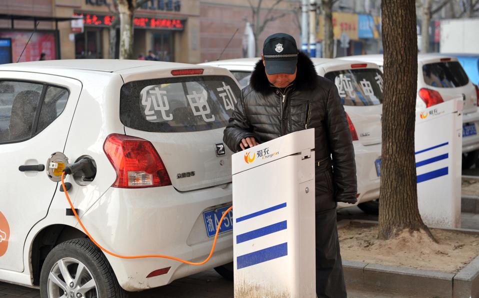 A driver charging an electric vehicle in China.