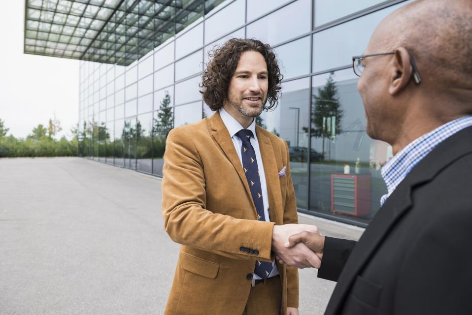 Ärimehed kahe raputatava käega kohtumisel multiracial