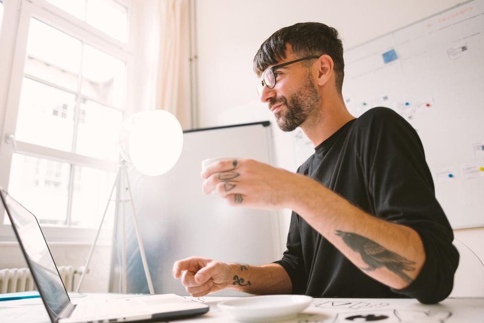 Depiction of a creative habit - Young Man Working At a Desk In Office