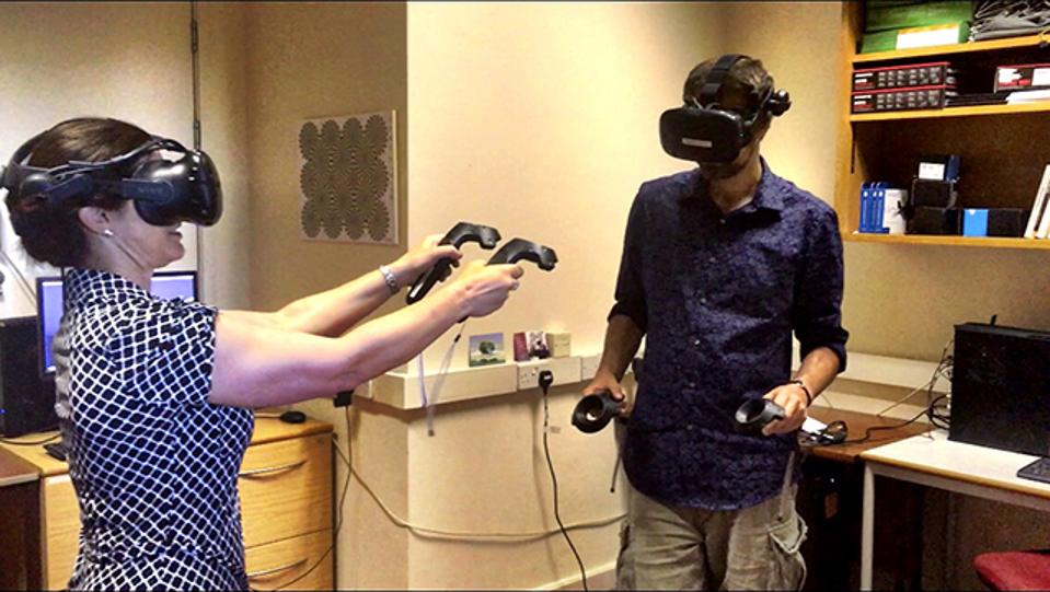 The author, left, and Dr. David Glowacki, cofounder of Interactive Scientific, toss virtual molecules at each other in Bristol Univesity's VR lab.