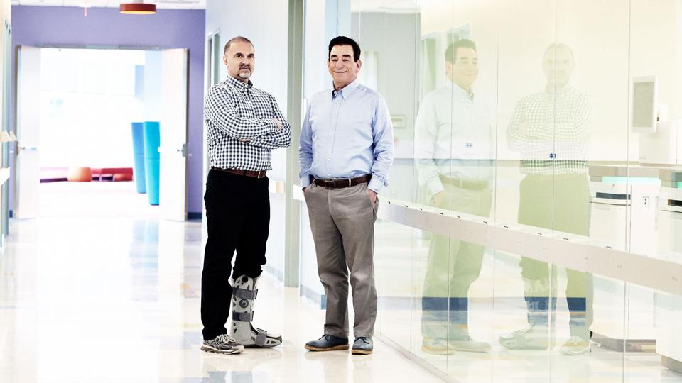 Regeneron chief scientific officer George Yancopoulos and CEO Len Schleifer stand in front of the Tarrytown, New York, lab where the DNA of 500,000 people is being sequenced.