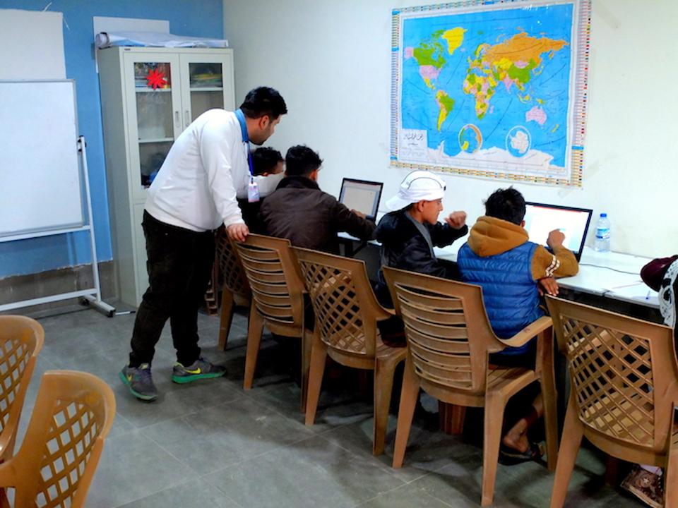 Young people learn valuable skills in a computer class at Debaga camp in Iraq's Erbil Governate.