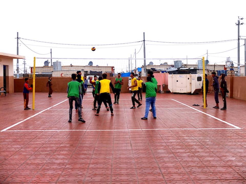 Boys play volleyball outside a series of offices for computer classes and women's vocational training in Debaga camp in northern Iraq.