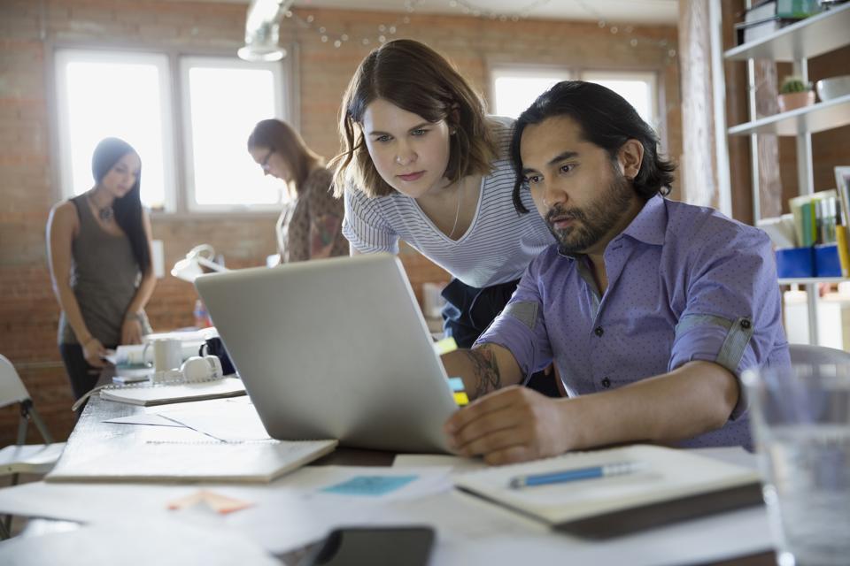 Designers using laptop in office