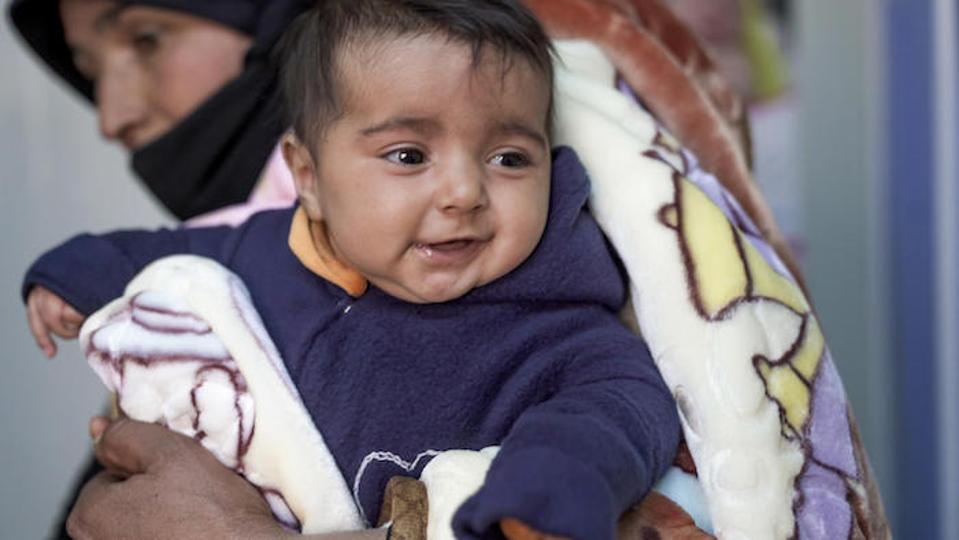En Jordania, Hala, de 3 meses de edad, viste un traje de lana cosido por refugiados sirios en un taller de costura respaldado por UNICEF en el campo de refugiados de Za'atari.