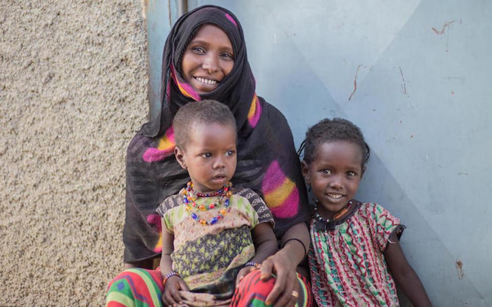 Chifra Woreda está protegiendo a sus hijas Kedija, 2, (en su regazo) y Hawa, 5, de ser sometidas a la mutilación genital femenina en la Región Afar de Etiopía.