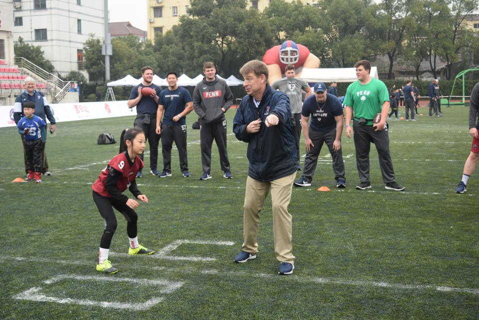 Young Chinese football players are becoming interested in American football.