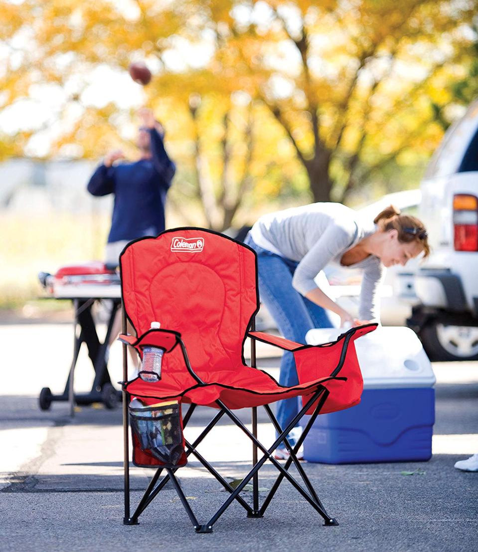 Red camping chair with woman getting into cooler in the background