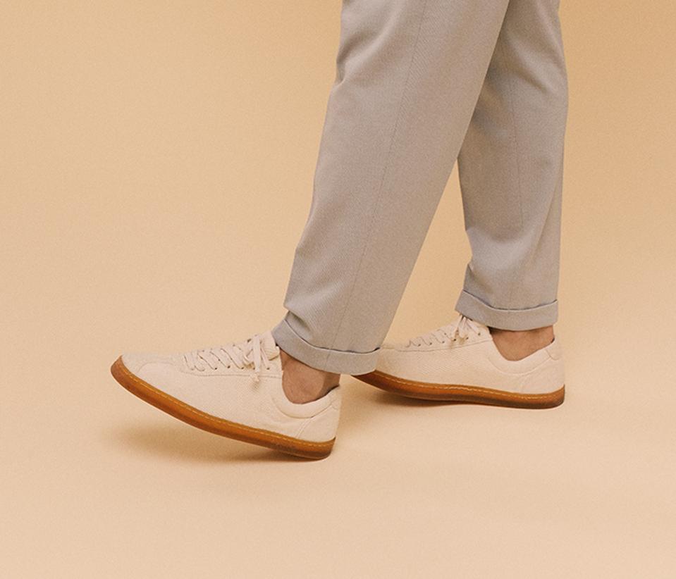 Man with roller up pants wearing off white shoes