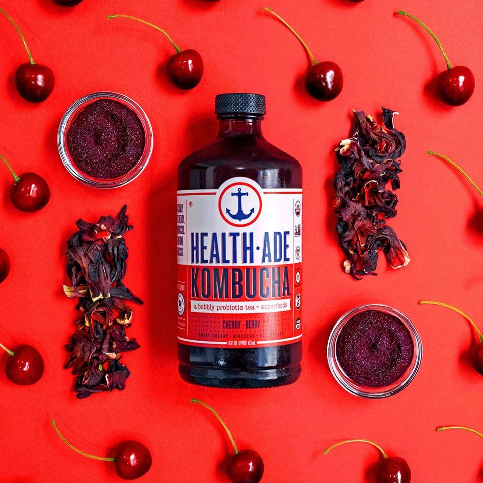 Kombucha bottle surrounded in cherries
