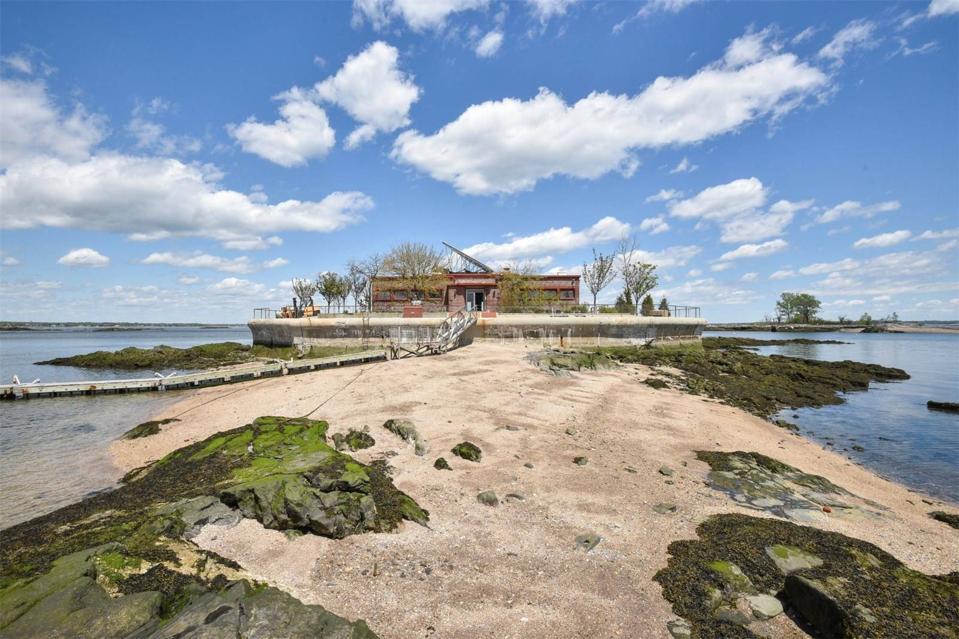 A sandy beach next to a brick house.