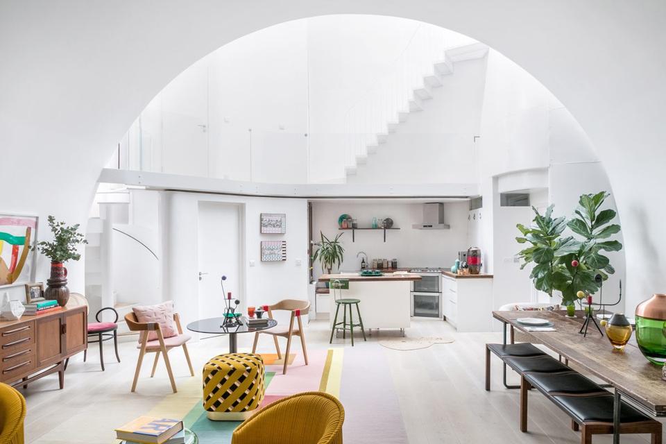 The central atrium of the house is lit brightly by the natural light coming in from the glass roof.