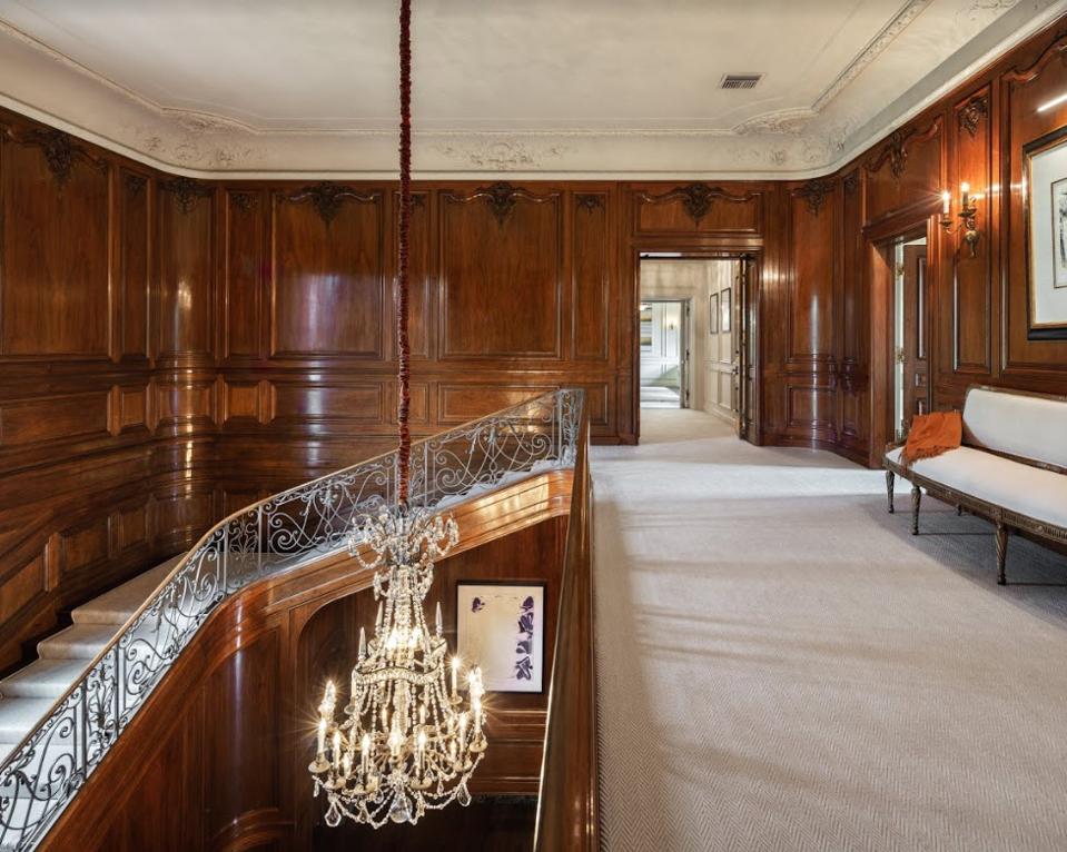 A grand spiral staircase and opulent chandelier anchors the home.