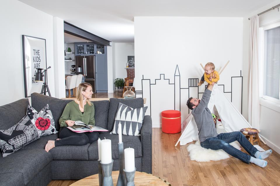 Mother, father and baby playing in their new living room.