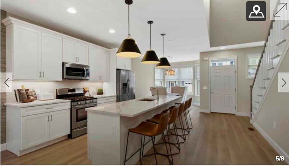 An open kitchen with a marble-topped island.