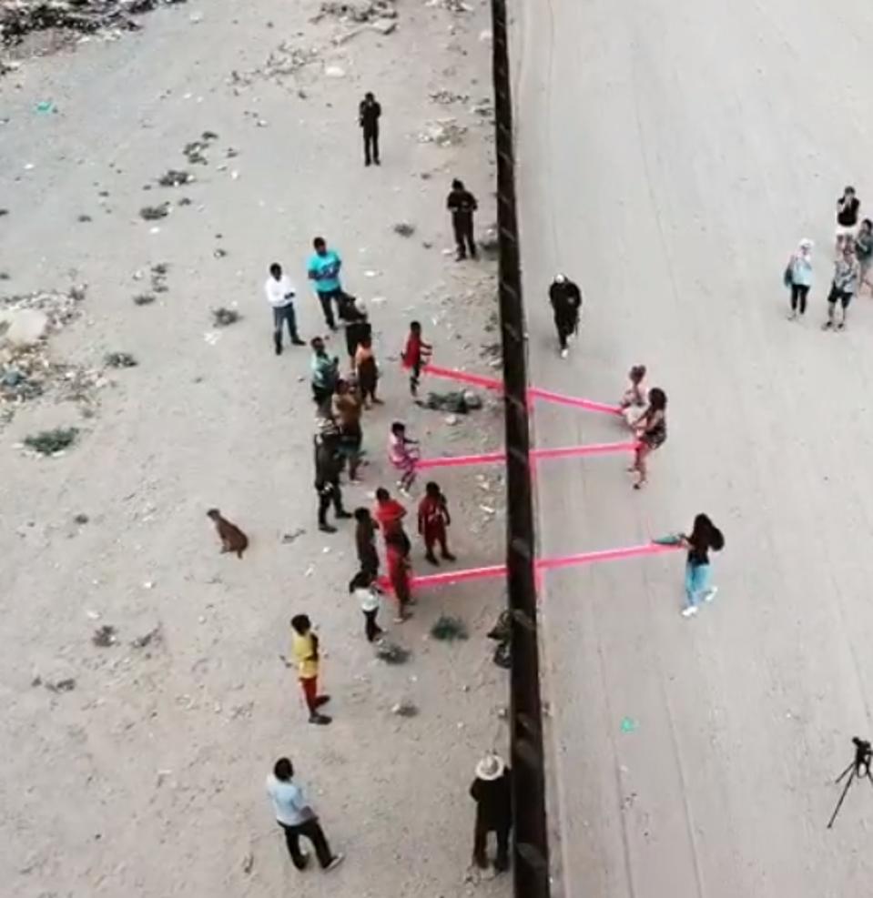 Ronald Rael and Virginia San Fratello installed hot pink seesaw at the Us-Mexico border on Saturday.