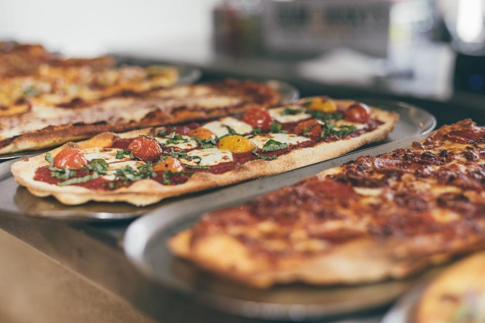 Une pizza au pain plat garnie de fromage et de différentes tomates.