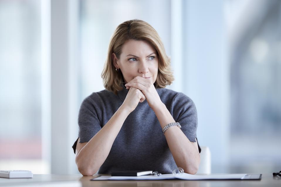 Pensive businesswoman looking away in conference room