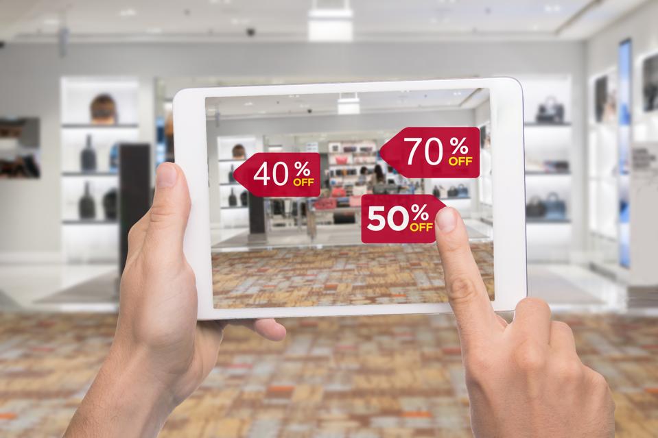 Concept de marketing de réalité augmentée. Hand holding digital tablet smart phone utiliser l'application AR pour vérifier le prix de vente spécial dans le centre commercial de magasin de mode au détail