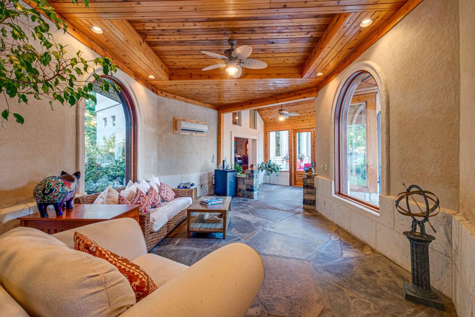 The home is ideal for entertaining with many different sitting areas from which to choose including a sun room (seen here).