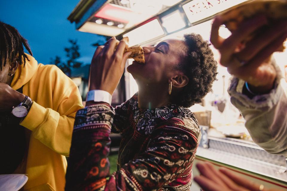 Jeune femme manger pizza au festival