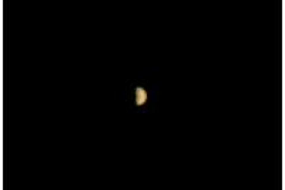 Color photo of distant Mars against the blackness of space.
