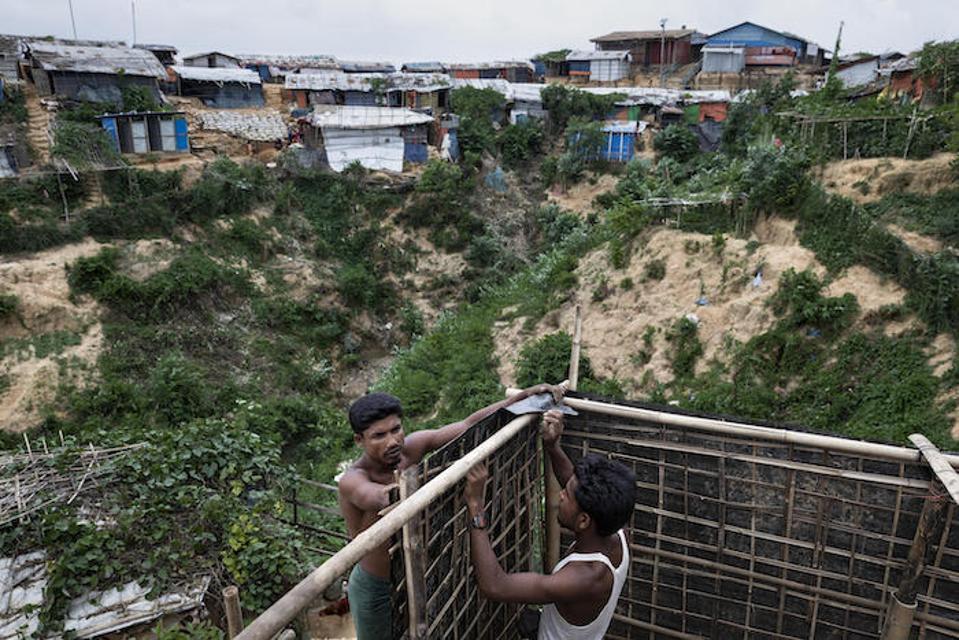 Preocupados por la seguridad de su madre y hermana, los hermanos Imam (izquierda), de 27 años, y Jahiruddin Hosain, de 21 años, construyeron un baño para los miembros de su familia en el montañoso campamento de refugiados Hakimpara Rohingya en Cox's Bazar, Bangladesh.