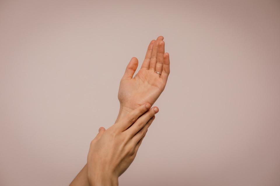 One hand caressing another.