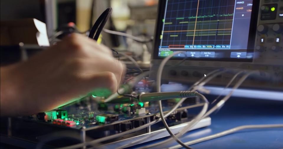 Close up of a hand bench testing a console motherboard