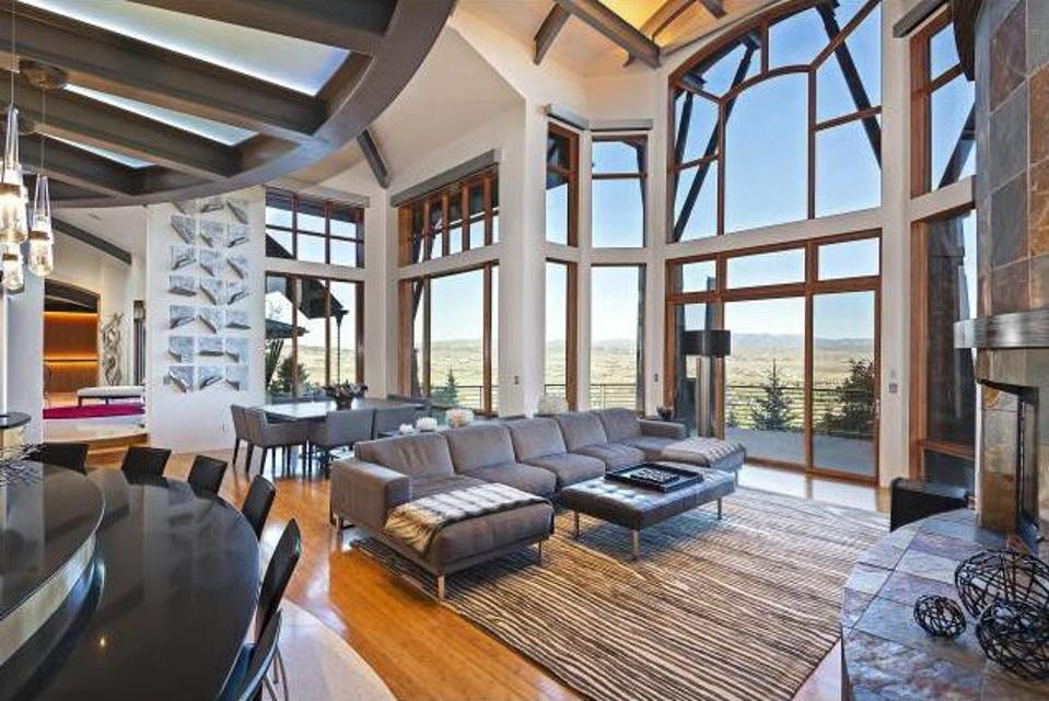 The interior features floor-to-ceiling windows, vaulted ceilings, and an open floor plan.