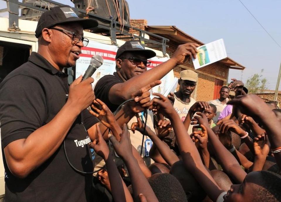 On August 7, 2019, Jean Louison Miango Makunda, UNICEF Burundi's Communication for Development (C4D) consultant on Ebola preparedness (center) distributes leaflets during an awareness event in Gatumba, Burundi.