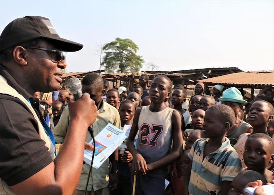 On August 7, 2019, Jean Louison Miango Makunda, UNICEF Burundi's Communication for Development (C4D) consultant on Ebola preparedness, speaks with children and distributes brochures in Gatumba, Burundi.