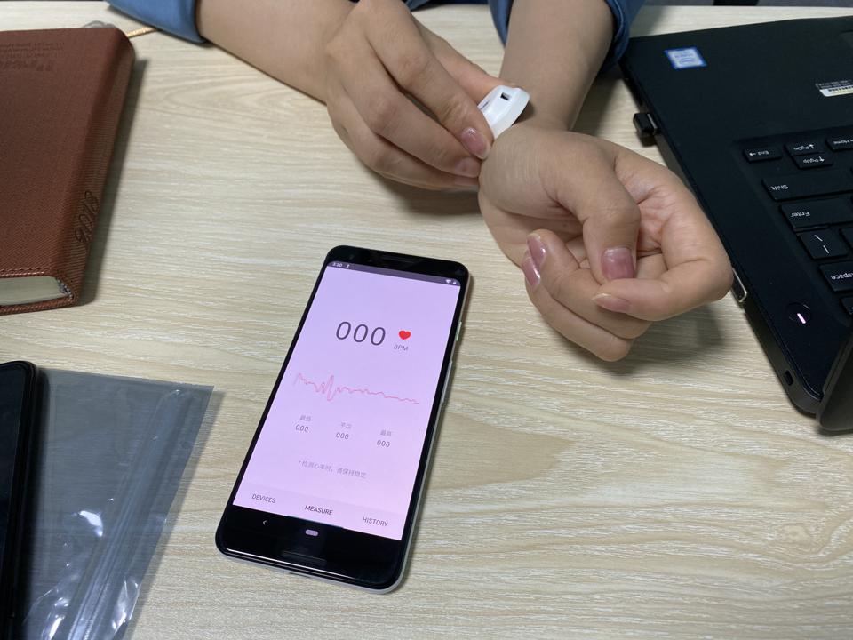An NDT employee demonstrating a small metal nub that can detect her pulse.