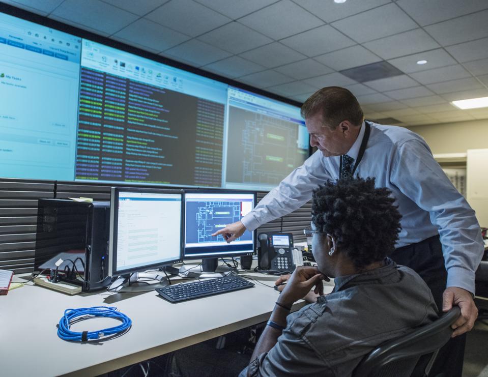 Colleagues working together in server control room