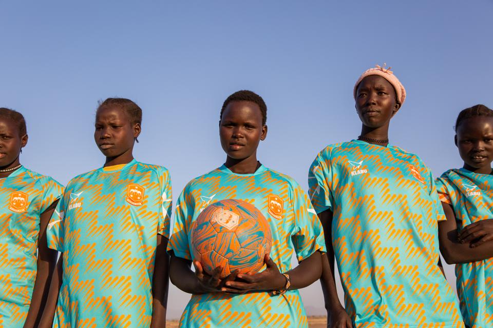 Members of Kalobeyei sports club in Kalobeyei Spirit home shirts.