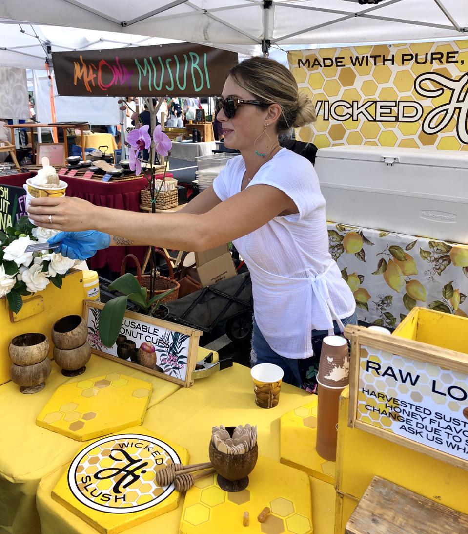 Co-founder, Ashley Moran, of Wicked Hi Slush serving slush at the Kakaʻako Farmers Market on Oʻahu