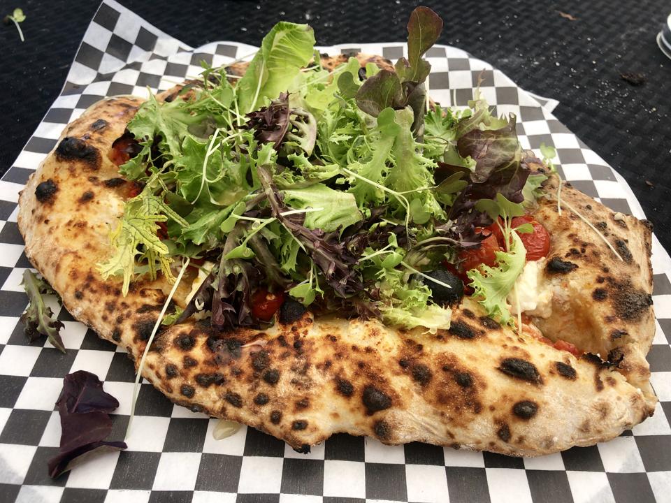 Wicked Hi Pizzaʻs Honey Goat Pizza with local greens, goats cheese and honey at the Kailua Farmers Market