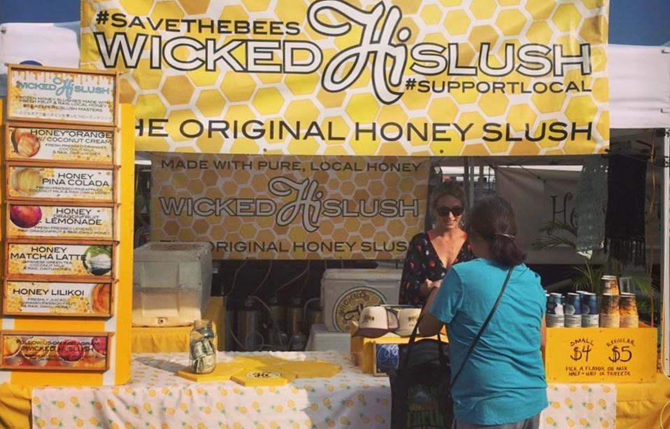 Moran talking honey with a customer at the Kailua Farmers Market on Oʻahu