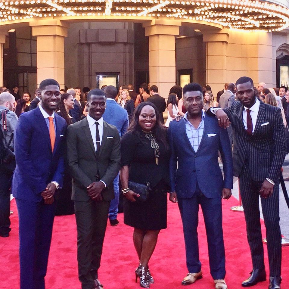 Four African men pose on the red carpet.