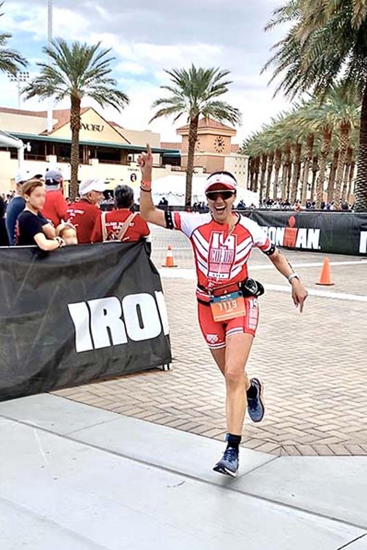 Triathlete woman finishing an Ironman event.